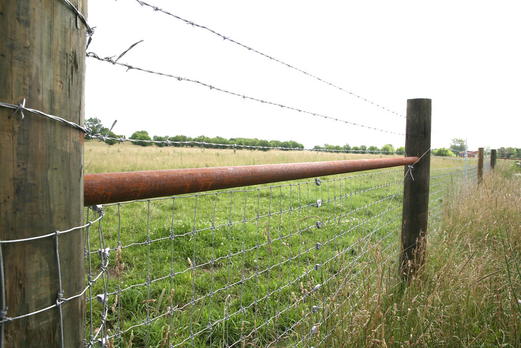 Woven wire field fence running from a wood brace assembly — illustrative product example