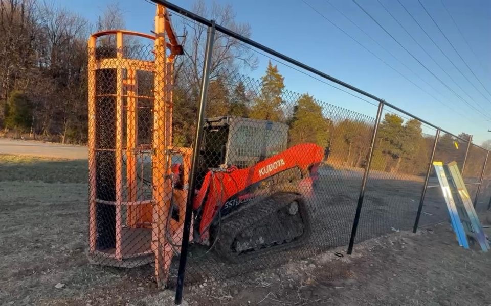 Kubota skid loader driving commercial fence posts at Four Roses project